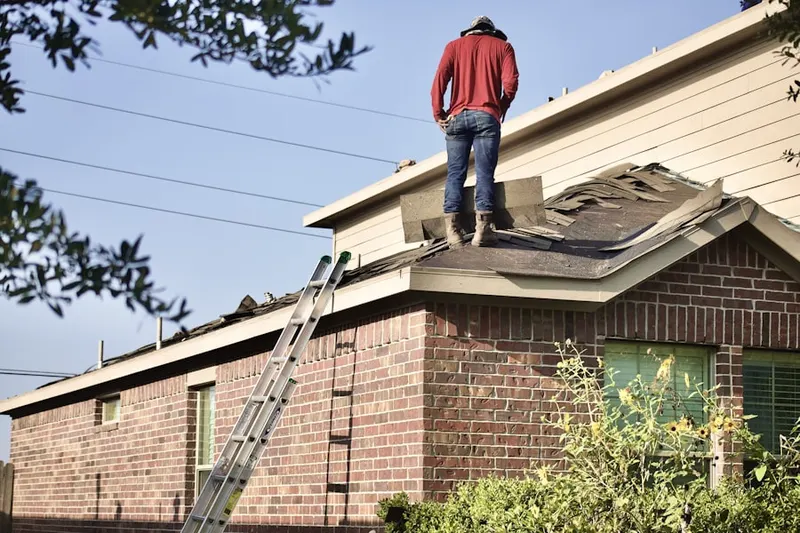 Professional roofer working on a residential roof in West Woodstock